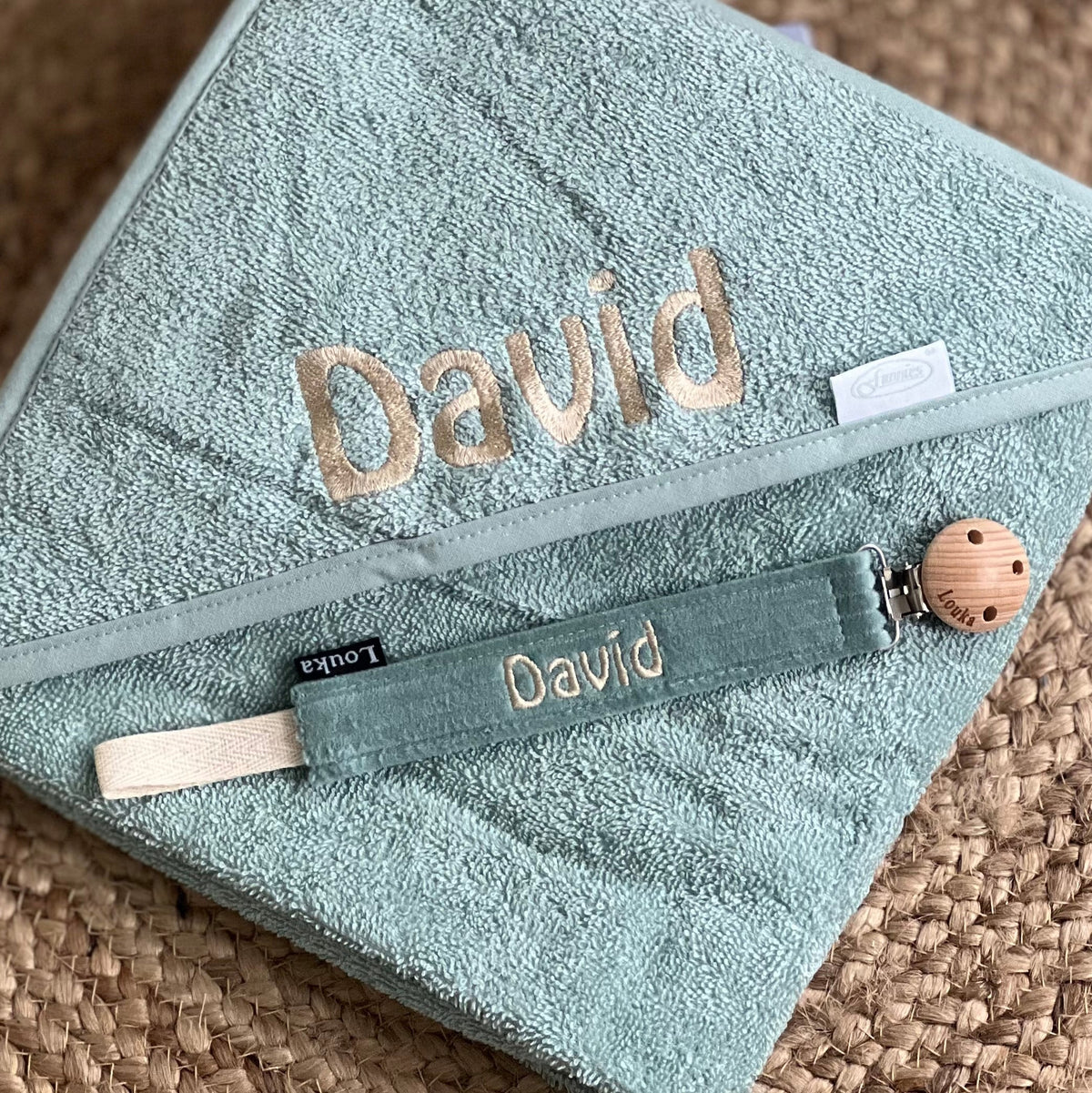 Close-up van geborduurde badcape met naam 'David' van Loukadesign